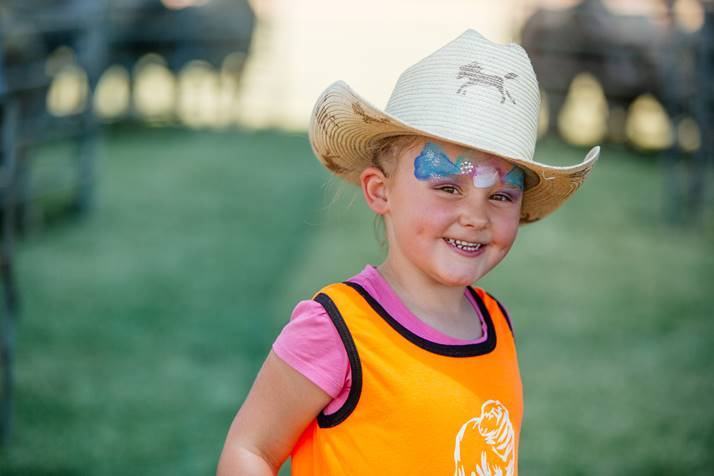 photo of little girl with face paint wearing a shearer's singlet and a cowboy hat